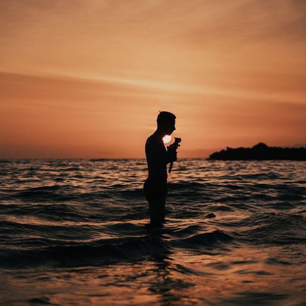 Silhouette of a person meditating against a warm, glowing background.